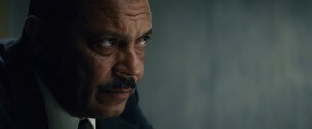 Movie still from “Black Mass” (2015), directed by Scott Cooper – An older man with a mustache looking at the camera; Close Up shot, Low angle
