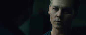 Movie still from “Black Mass” (2015), directed by Scott Cooper – A man's face in a dark room; Close Up shot, Over the shoulder angle