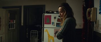 Movie still from “Black Mass” (2015), directed by Scott Cooper – A woman standing in front of an open refrigerator; Medium shot, Over the shoulder angle