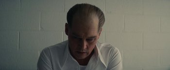 Movie still from “Black Mass” (2015), directed by Scott Cooper – A man in a white dress shirt is looking down; Close Up shot, Low angle