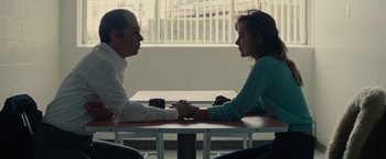 Movie still from “Black Mass” (2015), directed by Scott Cooper – A man and a woman sitting at a table holding hands; Medium shot, High angle