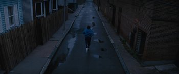 Movie still from “Black Mass” (2015), directed by Scott Cooper – A person running down a street in the dark; Extreme Wide shot, High angle