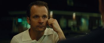 Movie still from “Black Mass” (2015), directed by Scott Cooper – A person with his hand to his face; Close Up shot, Over the shoulder angle