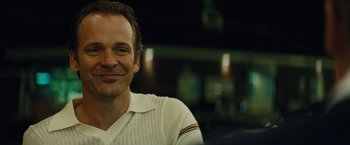 Movie still from “Black Mass” (2015), directed by Scott Cooper – A person smiling for the camera; Close Up shot, Over the shoulder angle