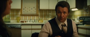Movie still from “Black Mass” (2015), directed by Scott Cooper – A man sitting in front of a counter in a kitchen; Close Up shot, Over the shoulder angle