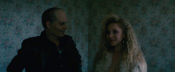 Movie still from “Black Mass” (2015), directed by Scott Cooper – A man standing next to a woman in front of a wall; Close Up shot, Over the shoulder angle