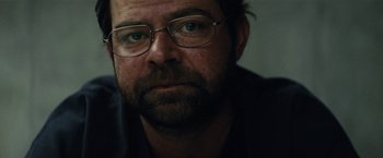 Movie still from “Black Mass” (2015), directed by Scott Cooper – A person wearing glasses; Close Up shot, Over the shoulder angle