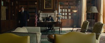Movie still from “Black Mass” (2015), directed by Scott Cooper – A man sitting at a desk in a library; Wide shot, High angle