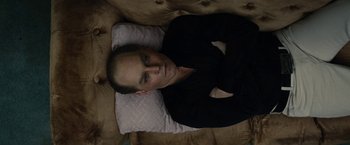 Movie still from “Black Mass” (2015), directed by Scott Cooper – A man laying on top of a pillow on top of a couch; Close Up shot, Overhead angle