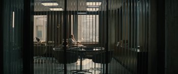 Movie still from “Black Mass” (2015), directed by Scott Cooper – A woman sitting at a table in front of a large window; Extreme Wide shot, High angle