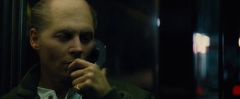 Movie still from “Black Mass” (2015), directed by Scott Cooper – A man holding a phone up to his ear; Close Up shot, High angle