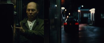 Movie still from “Black Mass” (2015), directed by Scott Cooper – A man sitting on a bus at night looking out of a window; Close Up shot, Low angle