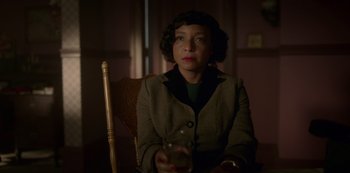 Movie still from “Fargo” (2014), created by Noah Hawley – A woman sitting in a chair holding a glass of wine; Close Up shot, High angle