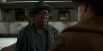 Movie still from “Fargo” (2014), created by Noah Hawley – An older man wearing a hat and glasses; Close Up shot, Over the shoulder angle