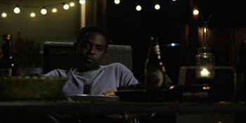 Movie still from “Blair Witch” (2016), directed by Adam Wingard – A man sitting at a table with a plate of food; Medium shot, Over the shoulder angle