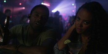 Movie still from “Blair Witch” (2016), directed by Adam Wingard – A man and a woman sitting at a table in front of a crowd; Close Up shot, High angle