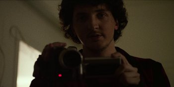 Movie still from “Blair Witch” (2016), directed by Adam Wingard – A man holding a video camera in front of a mirror; Extreme Close Up shot, Low angle