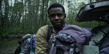 Movie still from “Blair Witch” (2016), directed by Adam Wingard – A man standing in front of a bunch of backpacks; Close Up shot, Low angle