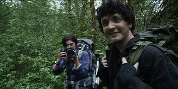 Movie still from “Blair Witch” (2016), directed by Adam Wingard – A man and a woman taking a picture in the woods; Close Up shot, Over the shoulder angle
