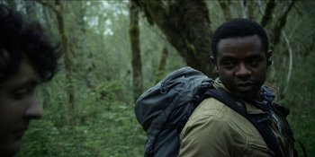 Movie still from “Blair Witch” (2016), directed by Adam Wingard – A man with a backpack in the woods; Close Up shot, Over the shoulder angle