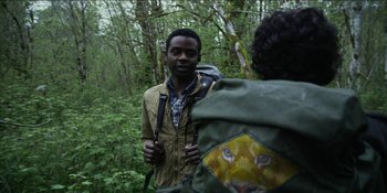 Movie still from “Blair Witch” (2016), directed by Adam Wingard – A man standing next to another man in the woods; Close Up shot, Over the shoulder angle