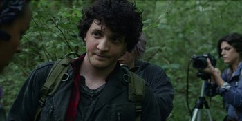 Movie still from “Blair Witch” (2016), directed by Adam Wingard – A man with curly hair is standing in the woods; Close Up shot, Over the shoulder angle