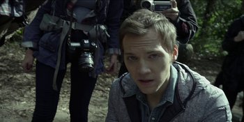 Movie still from “Blair Witch” (2016), directed by Adam Wingard – A man with a camera in the woods; Close Up shot, High angle