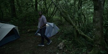 Movie still from “Blair Witch” (2016), directed by Adam Wingard – A man holding an umbrella walking through a forest; Wide shot, High angle