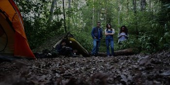 Movie still from “Blair Witch” (2016), directed by Adam Wingard – A group of people standing in the woods near a tent; Wide shot, Low angle