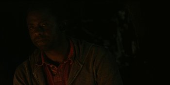 Movie still from “Blair Witch” (2016), directed by Adam Wingard – A man in a dark room wearing a jacket; Close Up shot, Over the shoulder angle