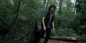 Movie still from “Blair Witch” (2016), directed by Adam Wingard – A man and a dog in the woods; Medium shot, Low angle
