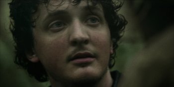 Movie still from “Blair Witch” (2016), directed by Adam Wingard – A man's face in the woods; Close Up shot, Over the shoulder angle