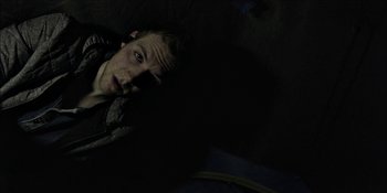 Movie still from “Blair Witch” (2016), directed by Adam Wingard – A man laying on the ground in the dark; Close Up shot, Overhead angle