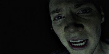 Movie still from “Blair Witch” (2016), directed by Adam Wingard – A person's face with a dark background; Extreme Close Up shot, Overhead angle