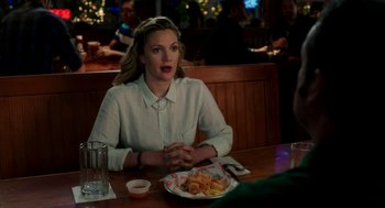 Movie still from “Blended” (2014), directed by Frank Coraci – A woman sitting at a table in front of a plate of food; Medium shot, Over the shoulder angle