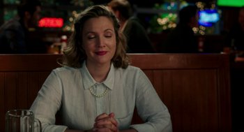 Movie still from “Blended” (2014), directed by Frank Coraci – A woman sitting at a table with her hands clasped together; Close Up shot, Over the shoulder angle