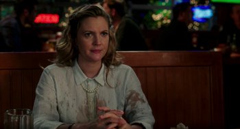 Movie still from “Blended” (2014), directed by Frank Coraci – A woman sitting at a table in front of a christmas tree; Medium shot, Over the shoulder angle