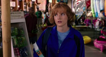 Movie still from “Blended” (2014), directed by Frank Coraci – A woman with a backpack and a blue jacket is walking down the street; Close Up shot, Over the shoulder angle