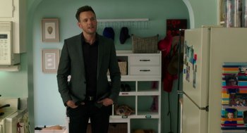 Movie still from “Blended” (2014), directed by Frank Coraci – A man in a suit standing in front of a white cabinet; Medium shot, Over the shoulder angle