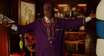 Movie still from “Blended” (2014), directed by Frank Coraci – A man in a purple suit with a necklace of beads; Medium shot, Low angle