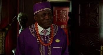 Movie still from “Blended” (2014), directed by Frank Coraci – A man in a purple suit and orange beads; Close Up shot, Over the shoulder angle