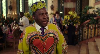 Movie still from “Blended” (2014), directed by Frank Coraci – A man wearing a colorful outfit and a hat; Medium shot, Over the shoulder angle