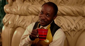 Movie still from “Blended” (2014), directed by Frank Coraci – A man holding a coffee cup while sitting on a couch; Close Up shot, High angle