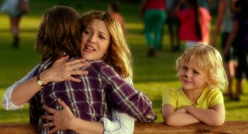Movie still from “Blended” (2014), directed by Frank Coraci – Two women hugging each other while two children look on; Medium shot, Over the shoulder angle