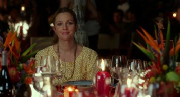 Movie still from “Blended” (2014), directed by Frank Coraci – A woman sitting at a table with a lot of candles in front of her; Medium shot, Over the shoulder angle