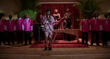 Movie still from “Blended” (2014), directed by Frank Coraci – A group of people standing on a stage with a microphone; Wide shot, High angle