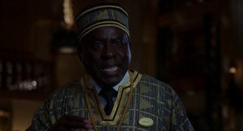 Movie still from “Blended” (2014), directed by Frank Coraci – A man in a suit and tie standing in front of a wall; Close Up shot, Over the shoulder angle