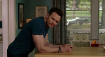 Movie still from “Blended” (2014), directed by Frank Coraci – A man leaning on a wooden table in a room; Medium shot, Over the shoulder angle