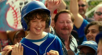 Movie still from “Blended” (2014), directed by Frank Coraci – A young boy wearing a baseball uniform and a helmet; Close Up shot, Over the shoulder angle