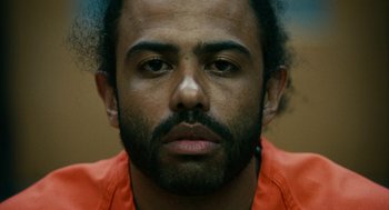 Movie still from “Blindspotting” (2018), directed by Carlos López Estrada – A person wearing an orange shirt; Close Up shot, Low angle